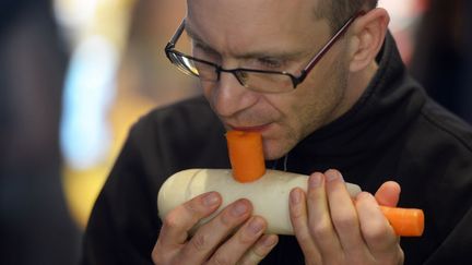 Un musicien du Vienna&nbsp;vegetable&nbsp;orchestra r&eacute;p&egrave;te avec des l&eacute;gumes transform&eacute;s en instrument avant de donner un concert au march&eacute; de San Miguel &agrave; Madrid (Espagne), le 13 mai 2013. (DOMINIQUE FAGET / AFP)