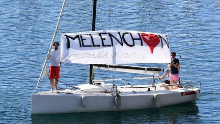 Des partisans de Jean-Luc mélenchon déployant une banderole à Marseille (Bouches-du-Rhône), lors d'un meeting de la France insoumise sur le Vieux-Port, le 9 avril 2017. (BORIS HORVAT / AFP)