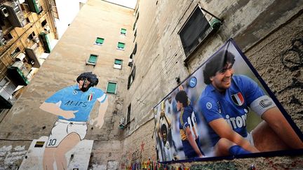 Des photos et une fresque de Diego Maradona recouvrent les murs d'un quartier de la ville de Naples (Italie) le 20 novembre 2019. (ALBERTO PIZZOLI / AFP)