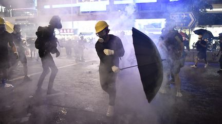 Des manifestants pro-démocratie au milieu des gaz lacrymogènes, le 28 juillet 2019, à Hong Kong. (ANTHONY WALLACE / AFP)