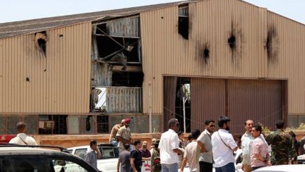 Des rebelles rassemblés devant le hangar où s'abitait le groupe pro-Kadhafi, Benghazi, le 31 juillet 2011 (AFP/ABDULLAH DOMA)