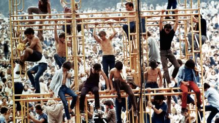 Woodstock, août 1969. Des festivaliers perchés au-dessus de la foule, un plan du documentaire de Michael Wadleigh consacré au festival et sorti en 1970. Ce documentaire a été récompensé par un Oscar. (WADLEIGH MAURICE / AFP)