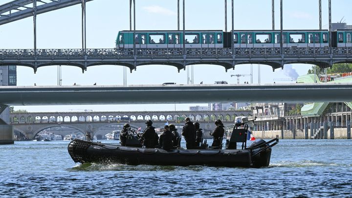 Un Zodiac de la brigade fluviale patrouille sur la Seine en marge d'un test technique de la future cérémonie d'ouverture des Jeux de Paris 2024, le 17 juillet 2023. (BERTRAND GUAY / AFP)