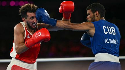 Le Français Sofiane Oumiha (à gauche) face au Cubain Erislandy Alvarez, le 7 août 2024 en finale des Jeux olympiques de Paris à Roland-Garros. (MAURO PIMENTEL / AFP)