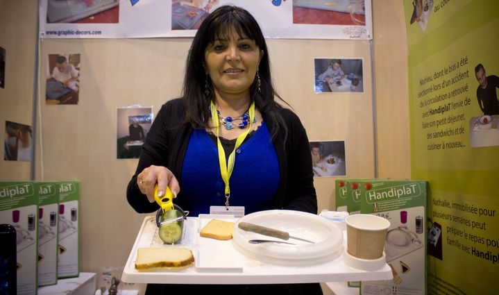 Rita Basile pr&eacute;sente le "Handiplat", un plateau-repas pour les personnes ayant perdu un bras ou une main, &agrave; la Foire de Paris, le 7 mai 2014. (MATHIEU DEHLINGER / FRANCETV INFO)