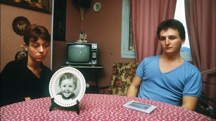 Christine et Jean-Marie Villemin, devant le portrait de leur fils Grégory,&nbsp;le 23 novembre 1984 à Epinal (Vosges). (ERIC FEFERBERG / AFP)