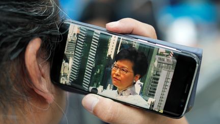 Le 15 juin, ce Hong Kongais tient son téléphone vissé à l'oreille pour ne rien perdre des annonces de Carrie Lam. La cheffe du gouvernement local&nbsp;annonce la suspension du projet de loi controversé sur les extraditions, sans fixer aucune date pour la réintroduction du texte. (JORGE SILVA / REUTERS)