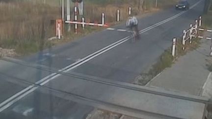 Capture d'écran montrant le cycliste polonais&nbsp;arrivant sur le passage à niveau, le 5 novembre 2015 à&nbsp;Opole, dans le&nbsp;sud du pays. (VWTOURANPOLAND / YOUTUBE)