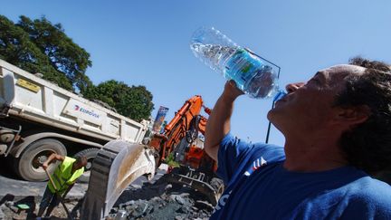 Un ouvrier se désaltère en pleine canicule à Caen (Calvados). (MYCHELE DANIAU / AFP)