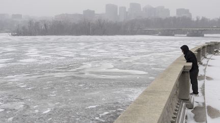 La tempête n'a pas (totalement) refroidi les touristes. Cet homme est venu observer les eaux gelées du fleuve Potomac, à Washington. (SAUL LOEB / AFP)