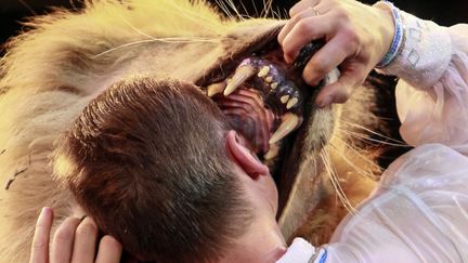 Le dresseur de lion,&nbsp;Oleksiy Pinko, met son visage dans la gueule d'un de ses fauves au cirque de Kiev (Ukraine), le 1er juin 2013. (GLEB GARANICH / REUTERS)