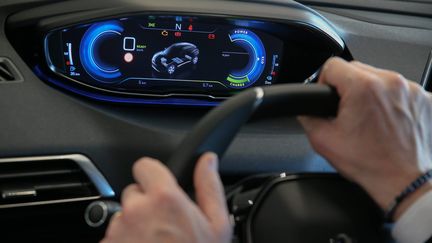 Un homme au volant d'une voiture électrique.&nbsp; (PIERRE HECKLER / MAXPPP)