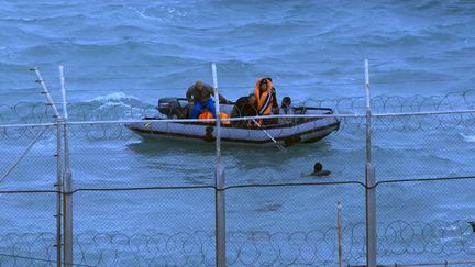 Des soldats marocains rep&ecirc;chent &agrave; la fronti&egrave;re maritime entre le Maroc et l'Espagne&nbsp;un homme qui tente d'immigrer, le 2 mars 2014. ( JUAN MEDINA / REUTERS)