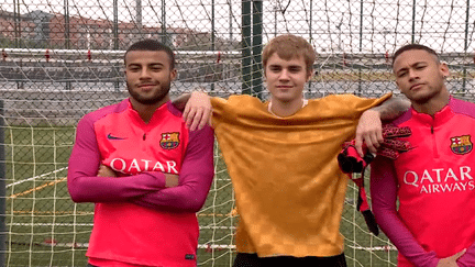 Justin Bieber à l'entraînement du Barça, entouré de Rafinha, à gauche, et de la star du football brésilien, Neymar.