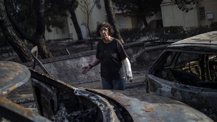 Une femme à Mati, en Grèce, après l'incendie violent et meurtrier, le 24 juillet 2018.&nbsp; (ANGELOS TZORTZINIS / AFP)