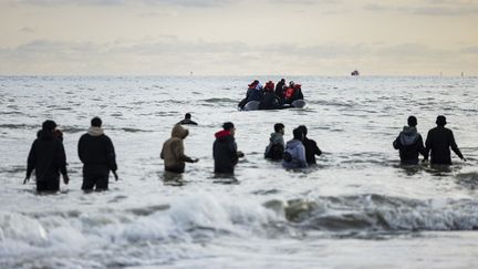 Migrants walk in the water after a boat left for England on April 26, 2024, on a beach in Gravelines (North). (SAMEER AL-DOUMY / AFP)