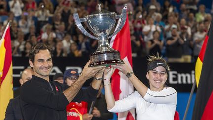 Les Suisses Roger Federer et Belinda Bencic soulèvent le trophée de la Hopman Cup, le 5 juin 2019 à Perth. (TONY ASHBY / AFP)