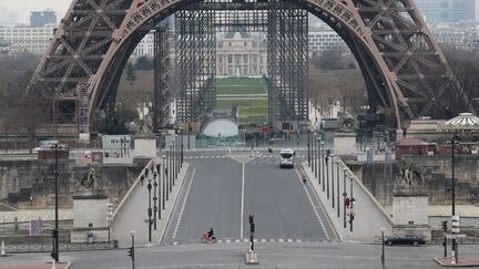 En temps normal, les touristes se pressent quotidiennement au pied de la tour Eiffel. Le Champs de Mars était toutefois vide, le&nbsp;17 mars 2020. (LUDOVIC MARIN / AFP)