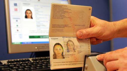 Une personne de l'Imprimerie nationale à Flers-en-Escrebieux (Nord) contrôle, le 12 avril 2006, dans l'atelier de fabrication, le nouveau passeport biométrique, obligatoire pour se rendre aux Etats-Unis (PHILIPPE HUGUEN / AFP)