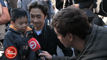 Un jeune enfant accompagné de son père, place de la République à Paris, dans une séquence diffusée par "Le Petit Journal" de Canal + lundi 16 novembre 2015. (LE PETIT JOURNAL / CANAL +)