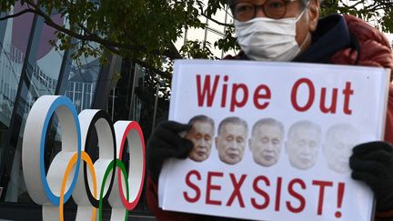 Un manifestant tient un slogan alors qu'il participe à un rassemblement contre le président de Tokyo 2020, Yoshiro Mori, devant le musée olympique à Tokyo, le 11 février 2021. (PHILIP FONG / AFP)