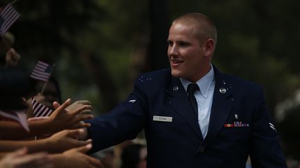 Spencer Stone salue la foule lors d'une parade &agrave; Sacramento (Californie, Etats-Unis), le 11 septembre 2015. (STEPHEN LAM / GETTY IMAGES NORTH AMERICA / AFP)