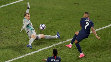 Mbappé lancé sur un côté, avec Neymar en position d'avant-centre, se heurte au&nbsp;gardien Manuel Neuer qui repousse sa tentative du pied, dans sa posture caractéristique. (POOL NEW / REUTERS)