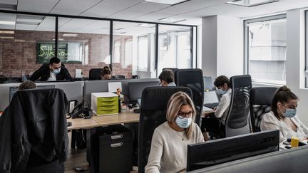 Des salariés portent des masques sur leur lieu de travail, à Lyon, le 1er septembre 2020. (JEFF PACHOUD / AFP)