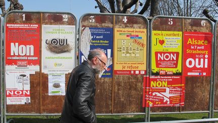 Un passant, mercredi 4 avril, devant des panneaux &eacute;lectoraux install&eacute;s &agrave; Schiltigheim (Bas-Rhin), avant le r&eacute;f&eacute;rendum sur la collectivit&eacute; territoriale unique d'Alsace. (FABIEN MAGNENOU / FRANCETV INFO)