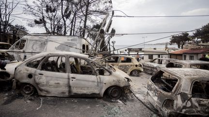 Des centaines de voitures brûlées ont été abandonnées&nbsp;à&nbsp;la station balnéaire de&nbsp;Mati,&nbsp;située à une quarantaine de kilomètres d'Athènes, mardi 24 juillet 2018.&nbsp; (CHRISTOPH SOEDER / DPA)