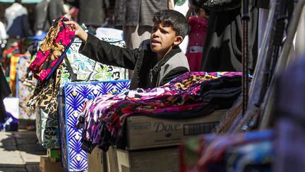 Un enfant vend du tissu sur un marché de Sanna (Yemen). (AFP)