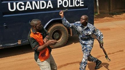 A Kampala, le 28 mai 2013: un policier ougandais s'en prend à un journaliste devant les locaux du «Daily Monitor» et du «Red Pepper», journaux indépendants fermés le 20 mai par la police. (AFP PHOTO / ISAAC KASAMANI)