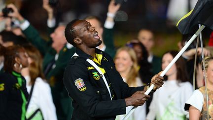 Le Jama&iuml;cain Usain Bolt, l'homme le plus rapide du monde, l&eacute;g&egrave;rement ralenti par son drapeau. (OLIVIER MORIN / AFP)