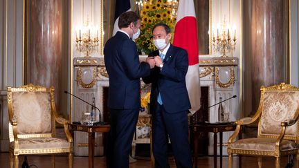 Le président français Emmanuel Macron et le Premier ministre Japonais, le 24 juillet 2021 à Tokyo (Japon). (CHARLY TRIBALLEAU / AFP)