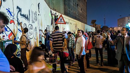 Ammar écrit «Efface» sur le mur de la rue Mohamed Mahmoud au Caire après le passage des autorités qui ont recouvert toutes les fresques. (Pauline Beugnies / Génération Tahrir)