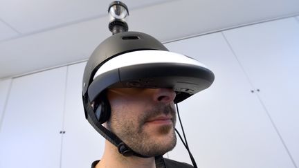 Un homme pr&eacute;sente le casque "FlyVIZ", qui permet de voir &agrave; 360 degr&eacute;s en temps r&eacute;el, &agrave; Paris, le 4 d&eacute;cembre 2012. (MIGUEL MEDINA / AFP)