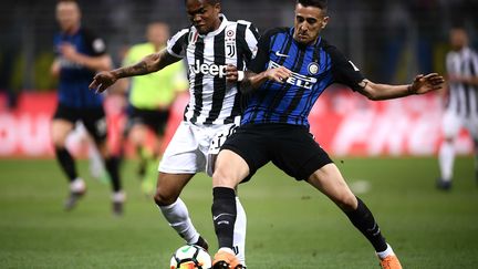 Douglas Costa, auteur du 1er but de la Juventus, ici aux prises avec l'Interiste Vecino. (MARCO BERTORELLO / AFP)