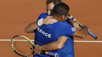 Richard Gasquet et Jo-Wilfried Tsonga se f&eacute;licitent apr&egrave;s leur victoire face &agrave; la R&eacute;publique tch&egrave;que, en demi-finale de la Coupe Davis, le 13 septembre 2014 au stade de&nbsp;Roland Garros &agrave; Paris. (PATRICK KOVARIK / AFP)