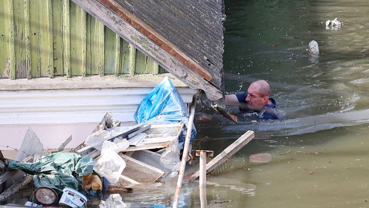 A resident of the flooded Kherson region tries to salvage what he can from his home on June 7, 2023. (OLEXANDER KORNYAKOV / AFP)