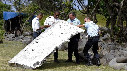 Des gendarmes manipulent un d&eacute;bris d'avion,&nbsp;sur le littoral de Saint-Andr&eacute; de La R&eacute;union.&nbsp; (MAXPPP)