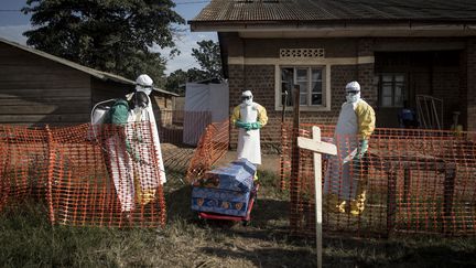 Le personnel médical congolais désinfecte le cercueil d'un défunt, à l'intérieur d'un centre de traitement d'Ebola. Photo prise à Béni, dans la province du Kivu, le 13 août 2018.&nbsp; (JOHN WESSELS / AFP)