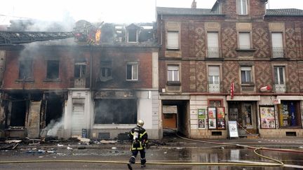 Un pompier devant la maison qui a br&ucirc;l&eacute; &agrave; Mulhouse (Haut-Rhin) faisant trois morts, le 1er novembre 2011. (SEBASTIEN BOZON / AFP)