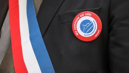 Un maire porte un badge "Ma commune est utile" à Paris, le 14 janvier 2019. (LUDOVIC MARIN / AFP)