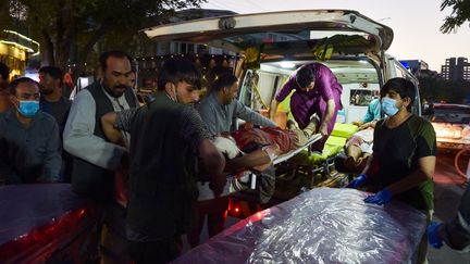 Des secours viennent en aide aux blessés à Kaboul (Afghanistan), après les explosions survenues près de l'aéroport, le 26 août 2021.&nbsp; (WAKIL KOHSAR / AFP)