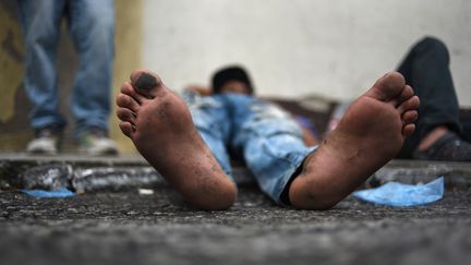 Un réfugié hondurien se repose devant la "Maison des migrants" de Guatemala City (Guatemala) avant de reprendre la route vers le Mexique, le 17 octobre 2018. (JOHAN ORDONEZ / AFP)