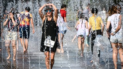 Des touristes se rafraîchissent, le 22 juin 2018. (MLADEN ANTONOV / AFP)