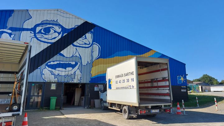 The immense fresco by Abbé Pierre, on the Emmaüs hangar in La Milesse (Sarthe). (AGATHE MAHUET / RADIO FRANCE)