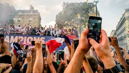 La foule célèbre le deuxième titre mondial de l'équipe de France de football, le 15 juillet 2018, sur les Champs-Elysées, à Paris. (SIMON GUILLEMIN / HANS LUCAS / AFP)