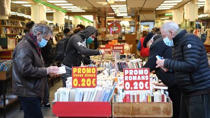 Des clients d'une librairie en train de choisir des livres, le 28 novembre 2020, à Paris.&nbsp; (ALAIN JOCARD / AFP)