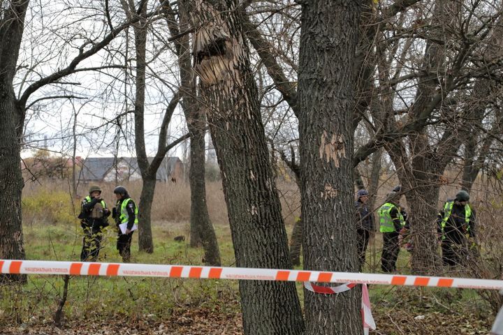 Des enquêteurs ukrainiens inspectent un parc de Kherson où l'armée russe a fusillé 17 membres de la défense territoriale ukrainienne après la libération de la ville, selon les autorités (photo prise le 16 novembre 2022). (NINA LIASHONOK / NURPHOTO / AFP)